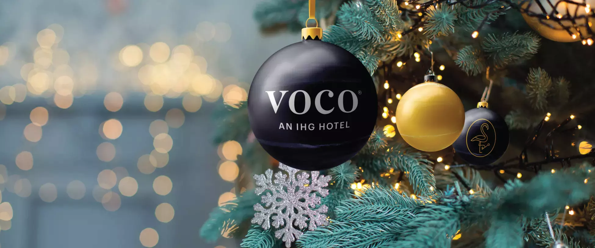 A voco® Bauble hanging in a Christmas tree.